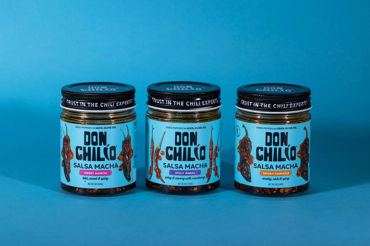 The three Don Chilio Salsa Macha jars — Smoky Chipotle, Sweet Morita and Spicy Árbol — lined up on a blue background.
